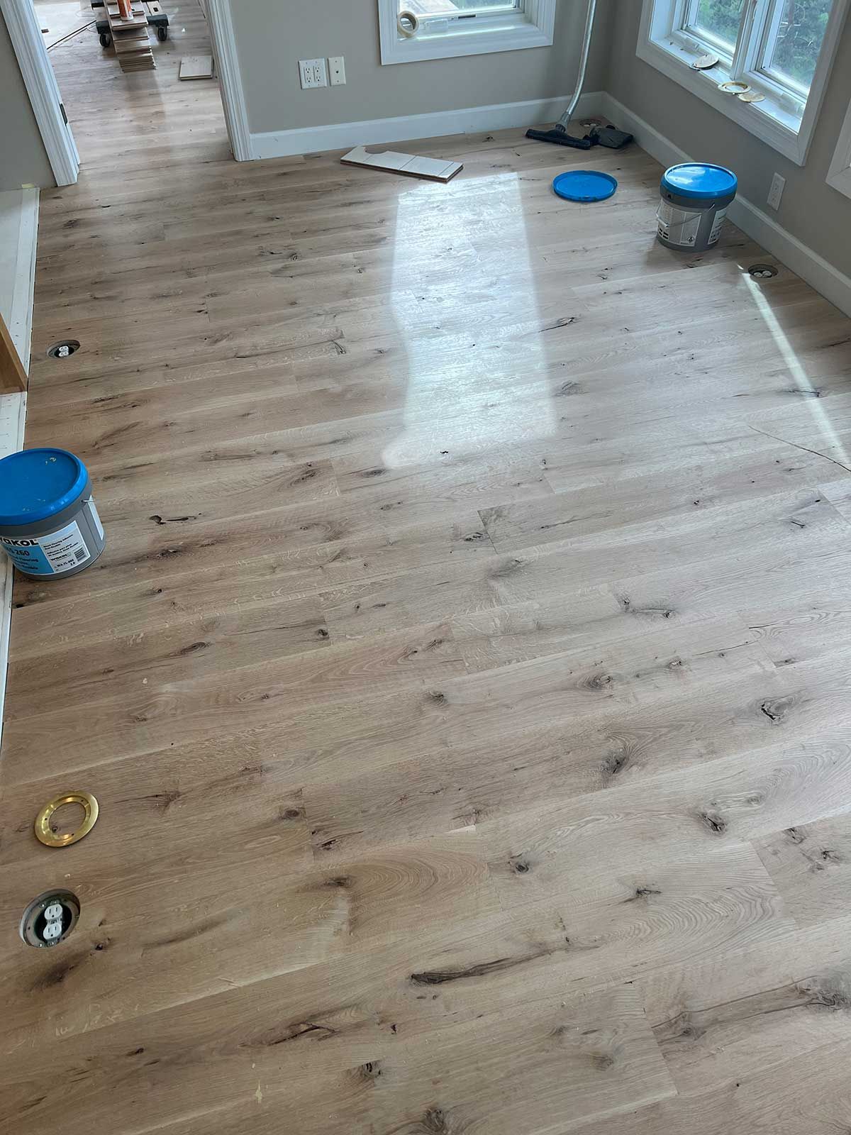 A room with hardwood floors and a mop on the floor.