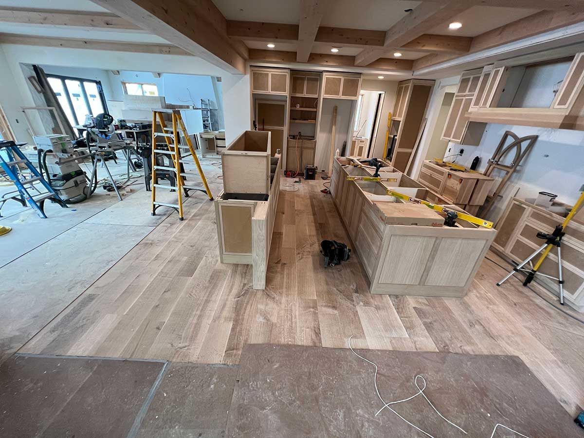 A kitchen is being remodeled with wooden cabinets and a large island.