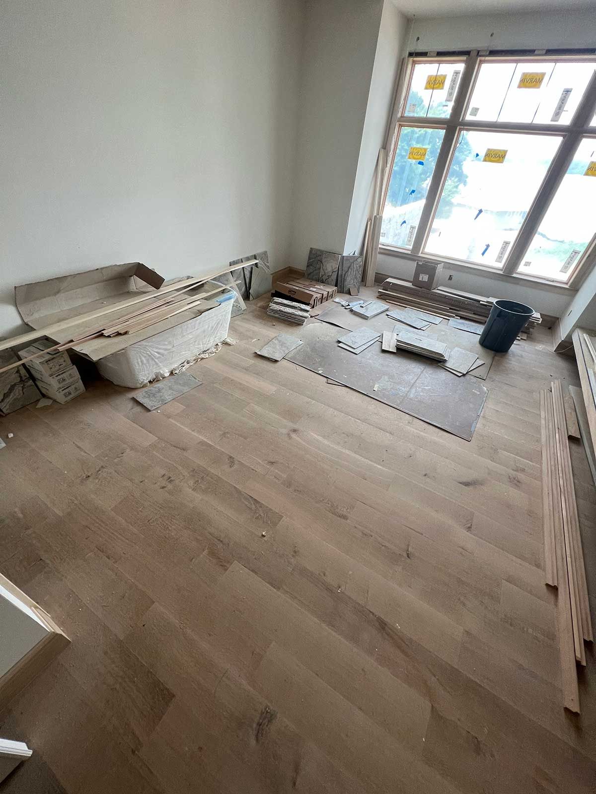 A room with hardwood floors and a large window.