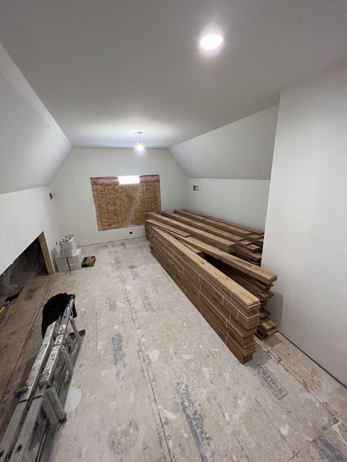 A room with a lot of wood in it and a ladder.