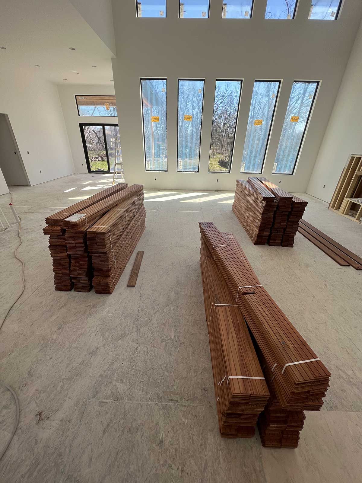 A large room with a lot of wood stacked on the floor.