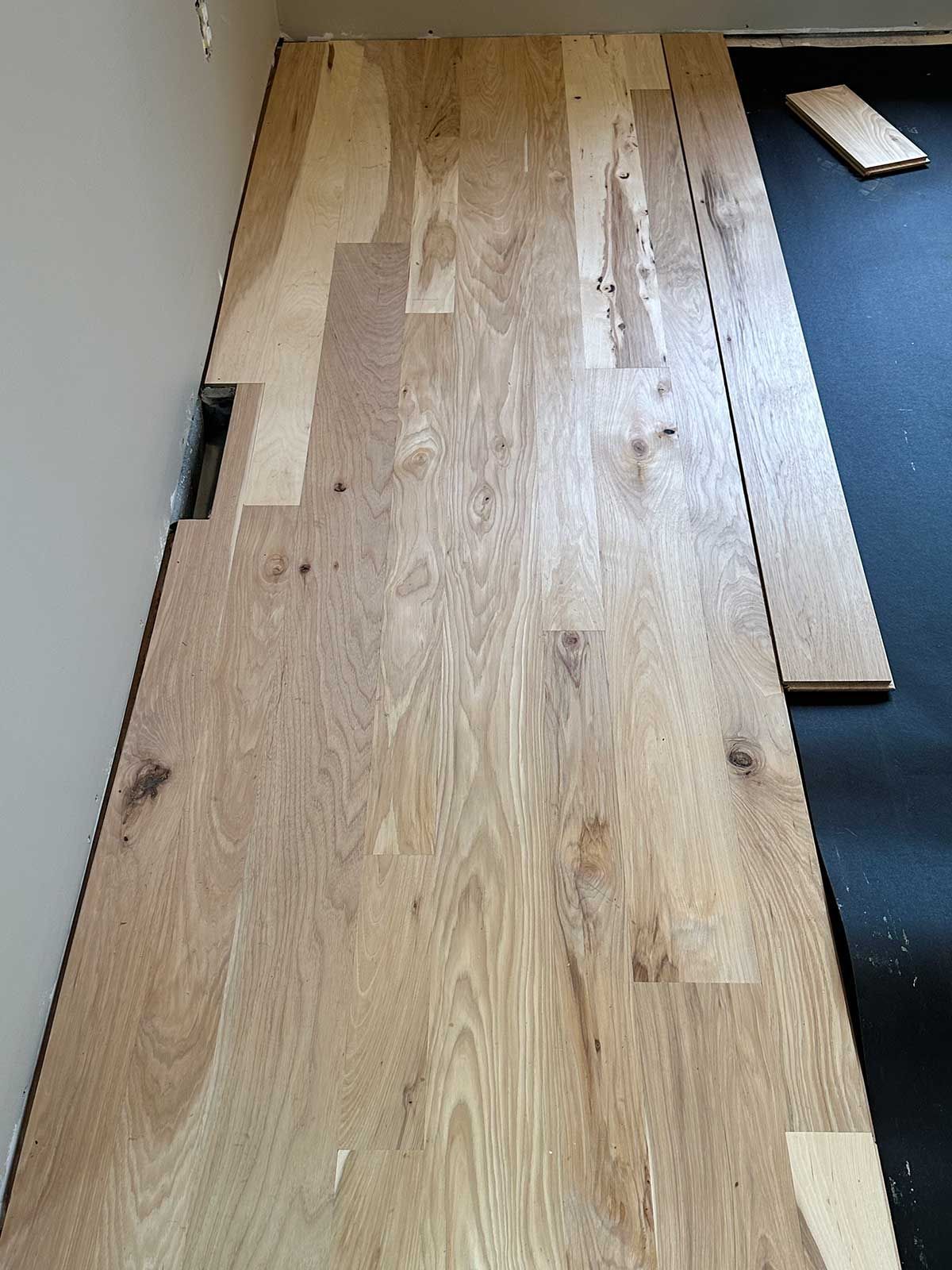 A wooden floor is being installed in a room
