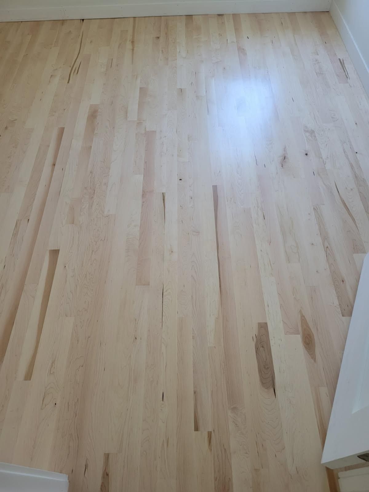 Light-colored hardwood floor with long planks.