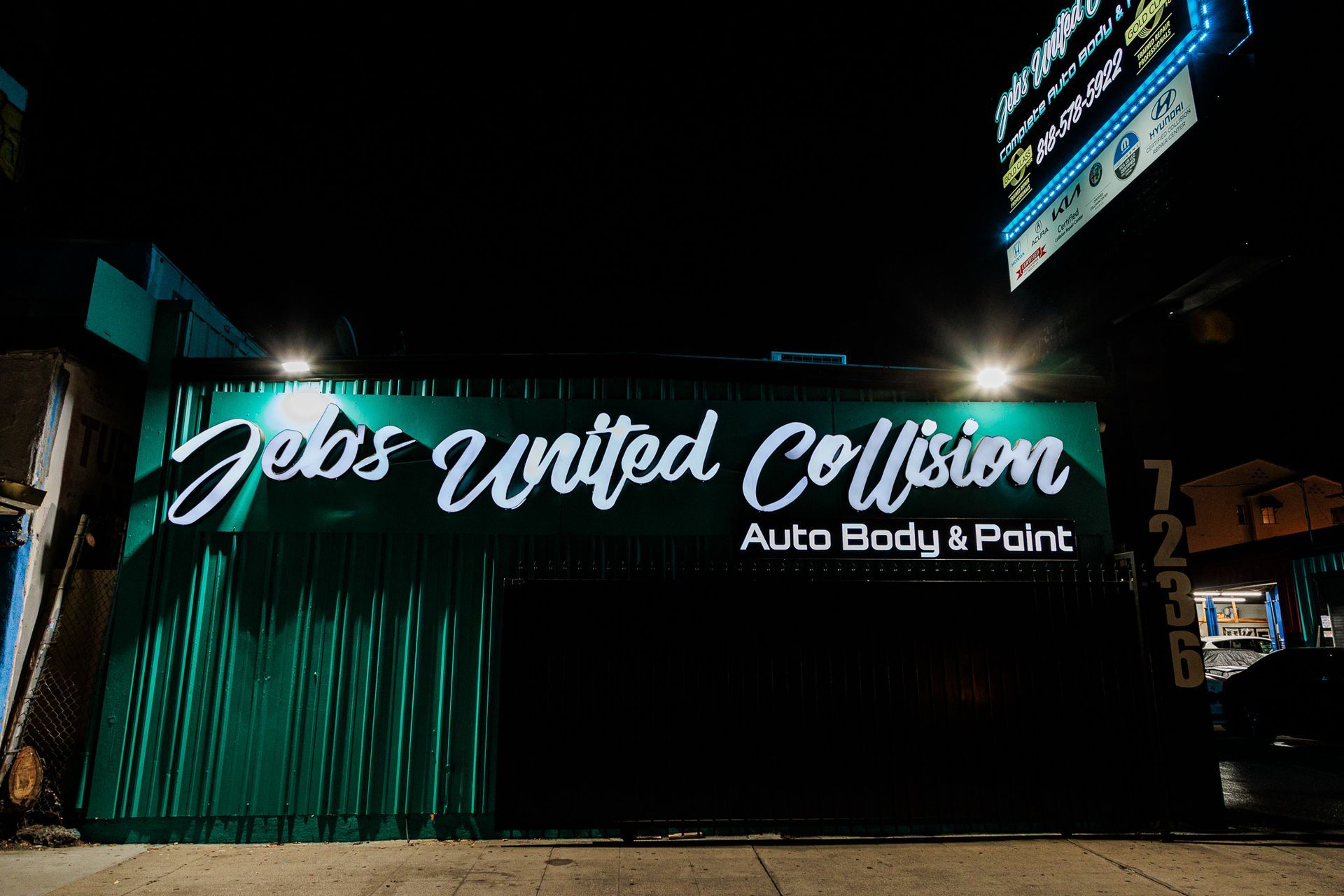 A green building with a sign that says gelas united collision auto body & paint.