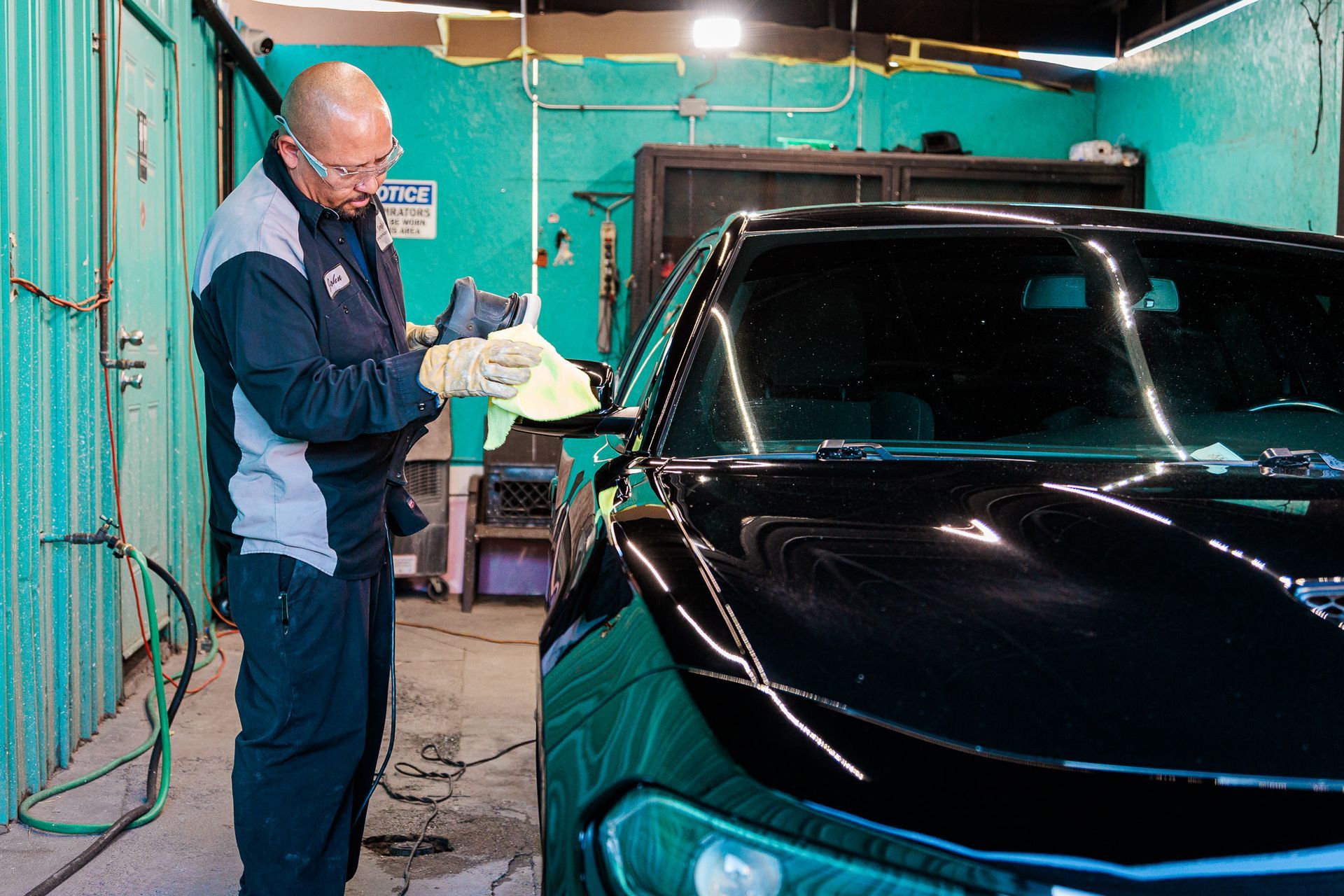 A man is polishing a black car