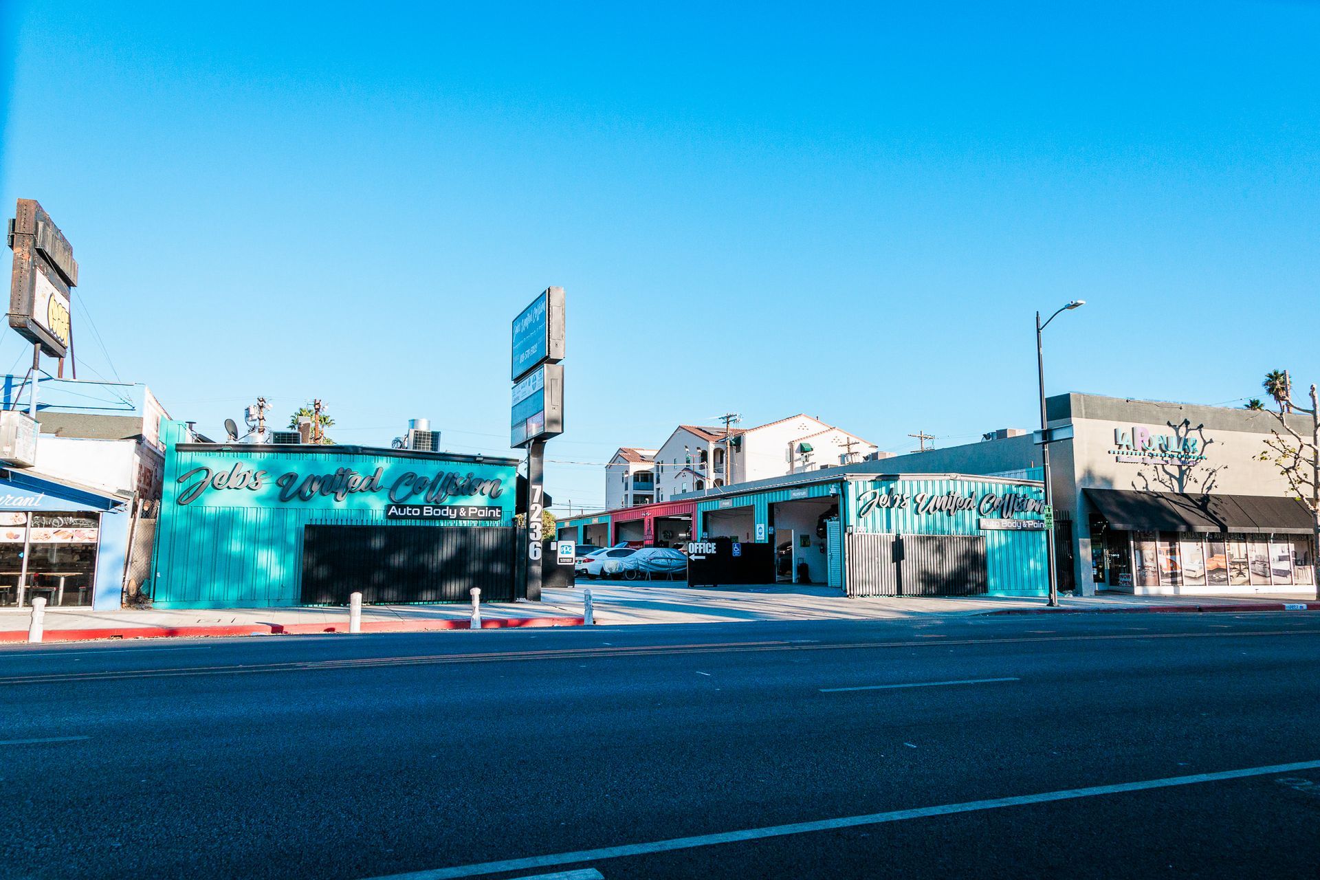A row of buildings are lined up on the side of a road.