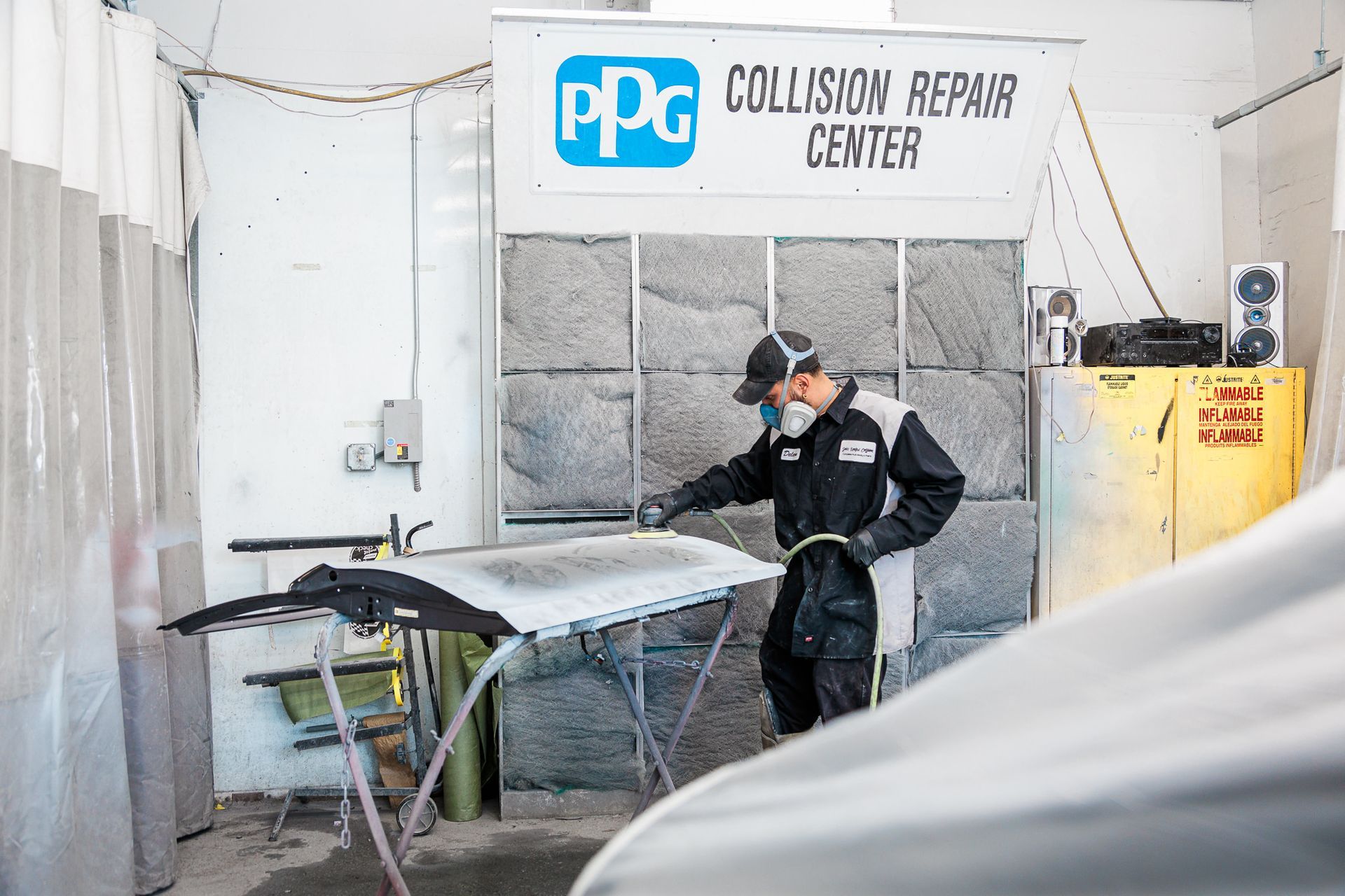 A man is working on a car in a collision repair center.