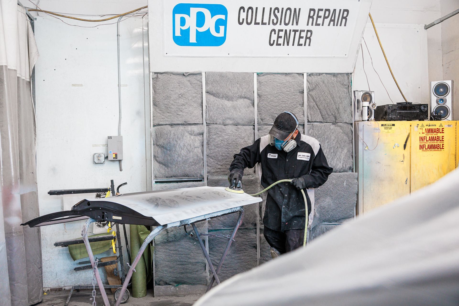 Man working on a car in a collision repair center.