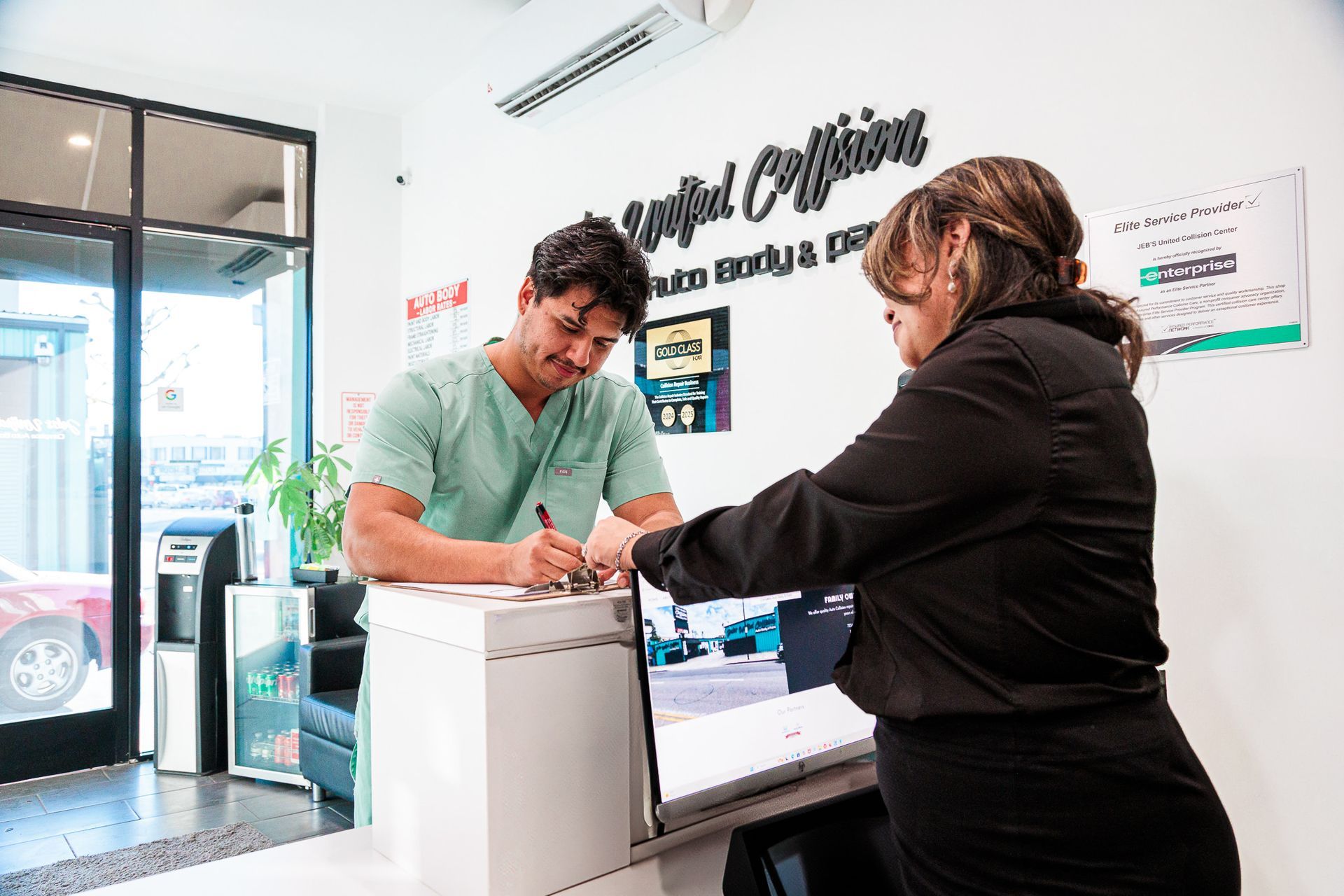 A man and a woman are standing at a counter in repair shop