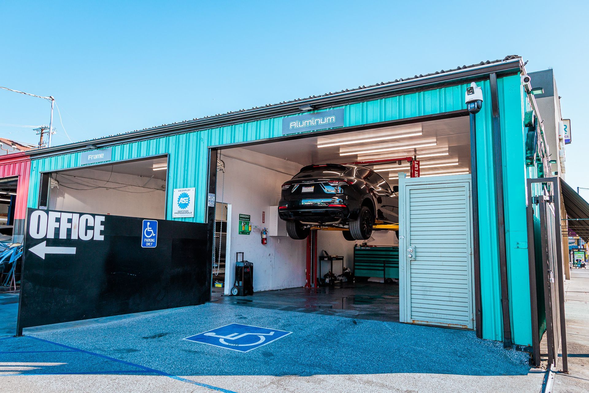 A car is sitting on a lift in a garage.