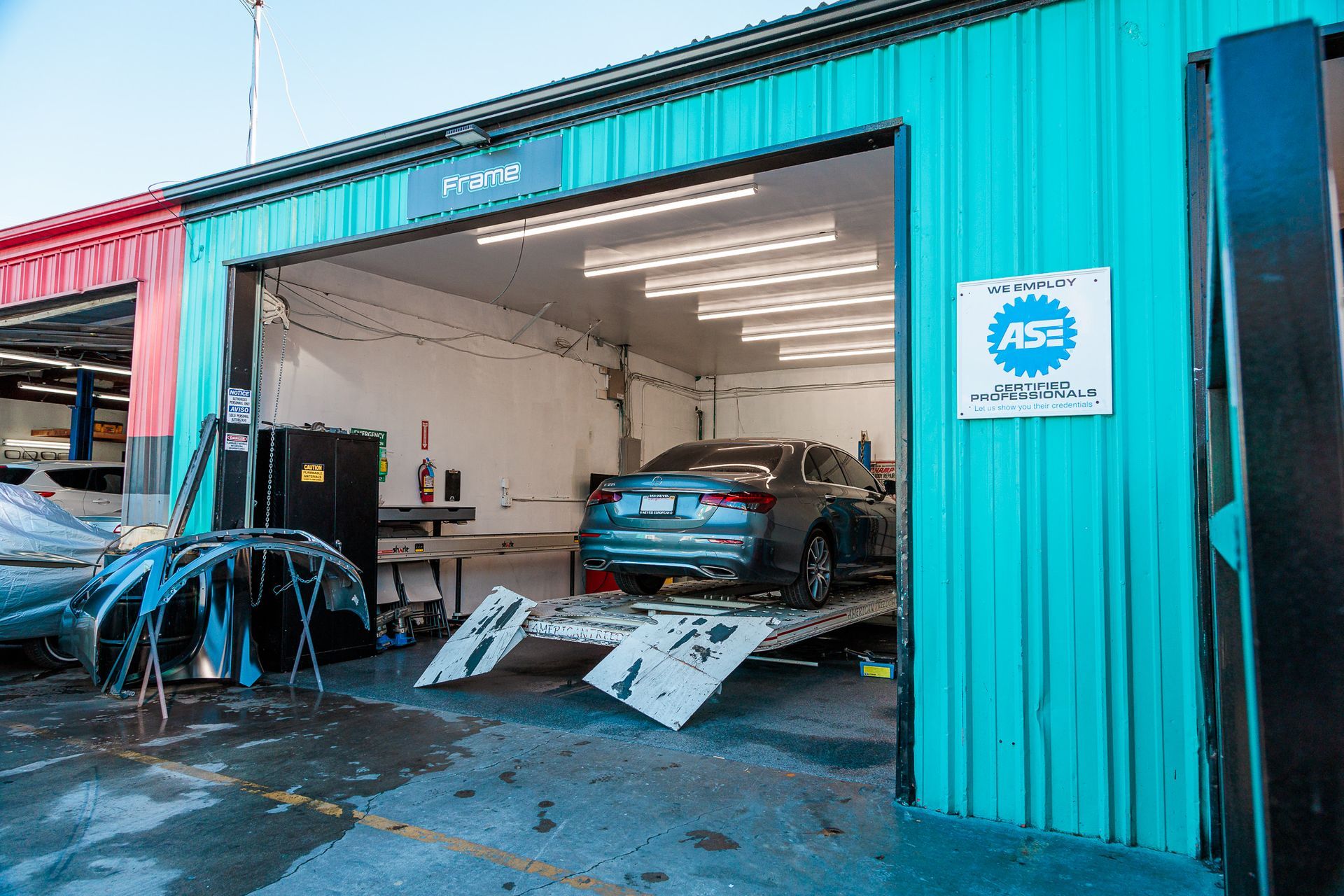 A car is sitting on a ramp in a garage.