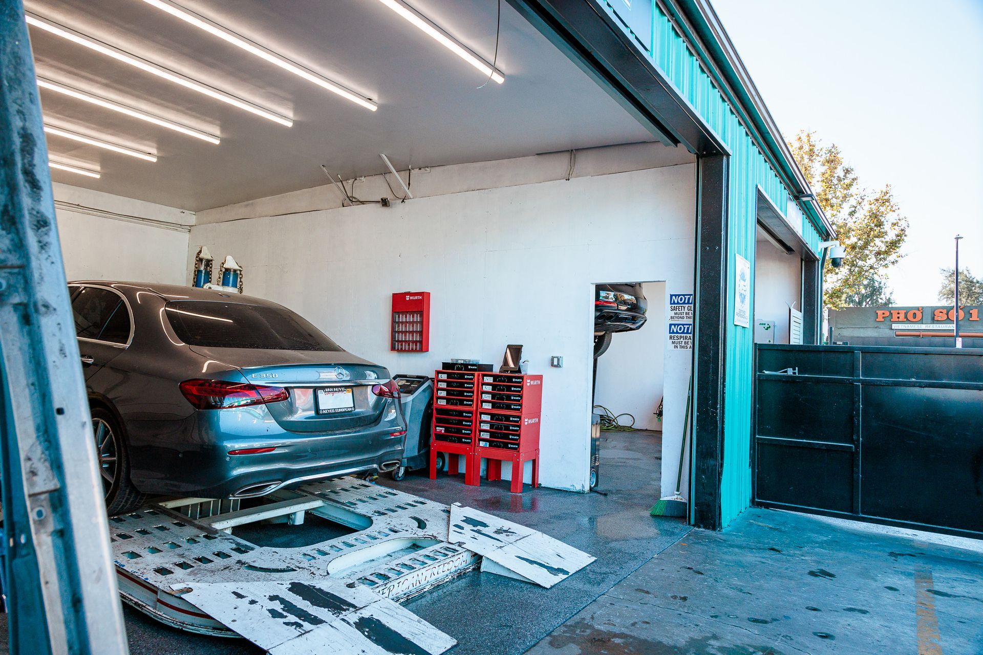 A car is sitting on a lift in a garage.