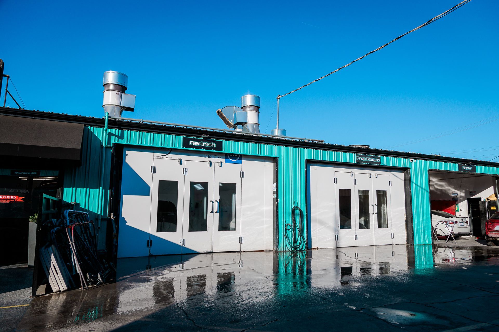 A green and white building with cars parked in front of it