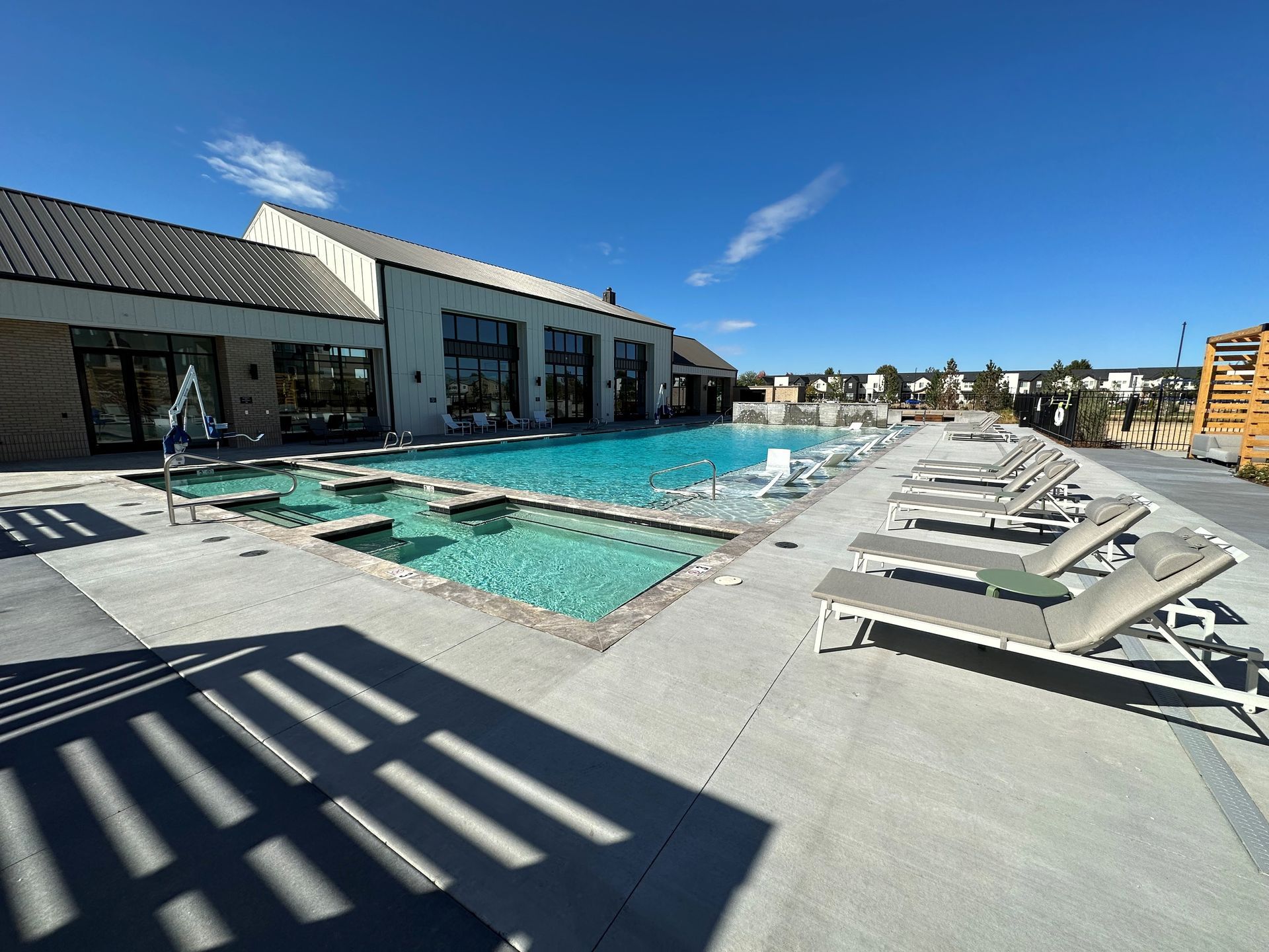 A large swimming pool surrounded by lounge chairs and umbrellas.