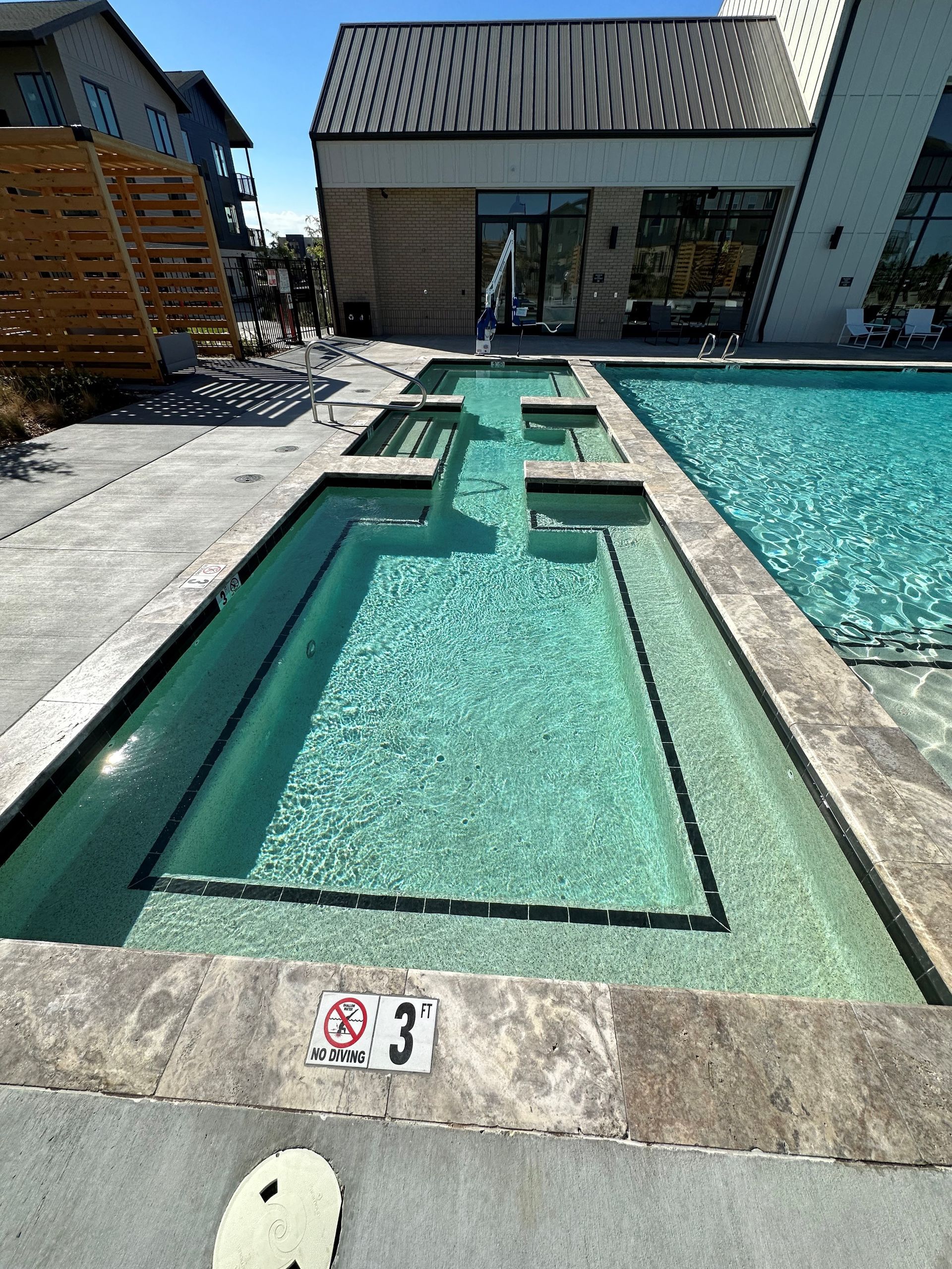 A large swimming pool with a fountain in the middle of it.