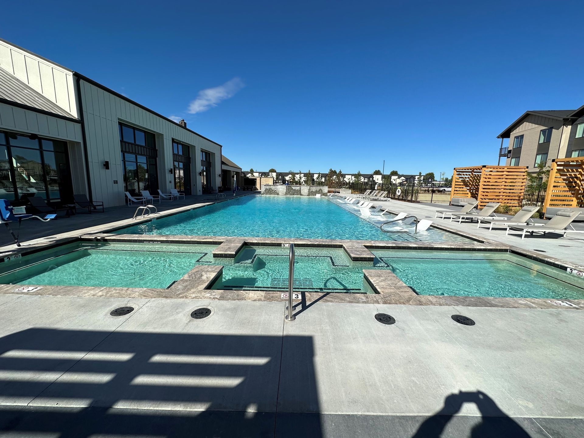A large swimming pool with a hot tub in the middle of it.
