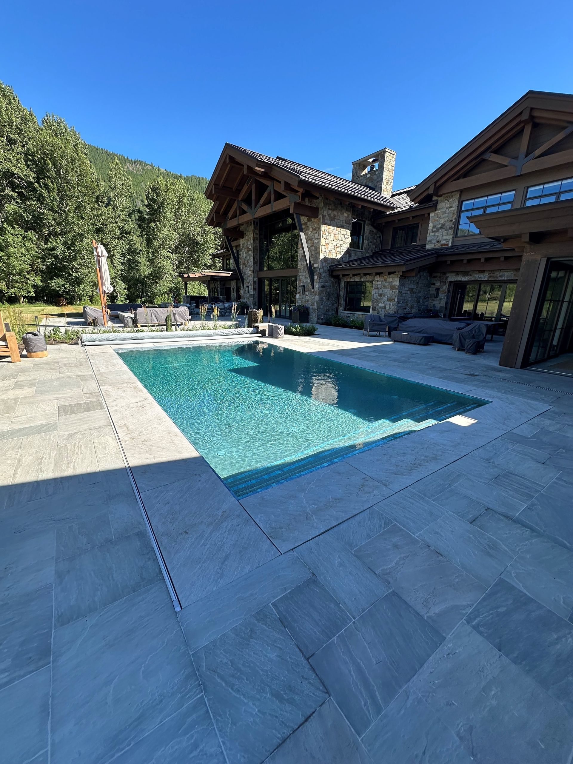 A large house with a large swimming pool in front of it.