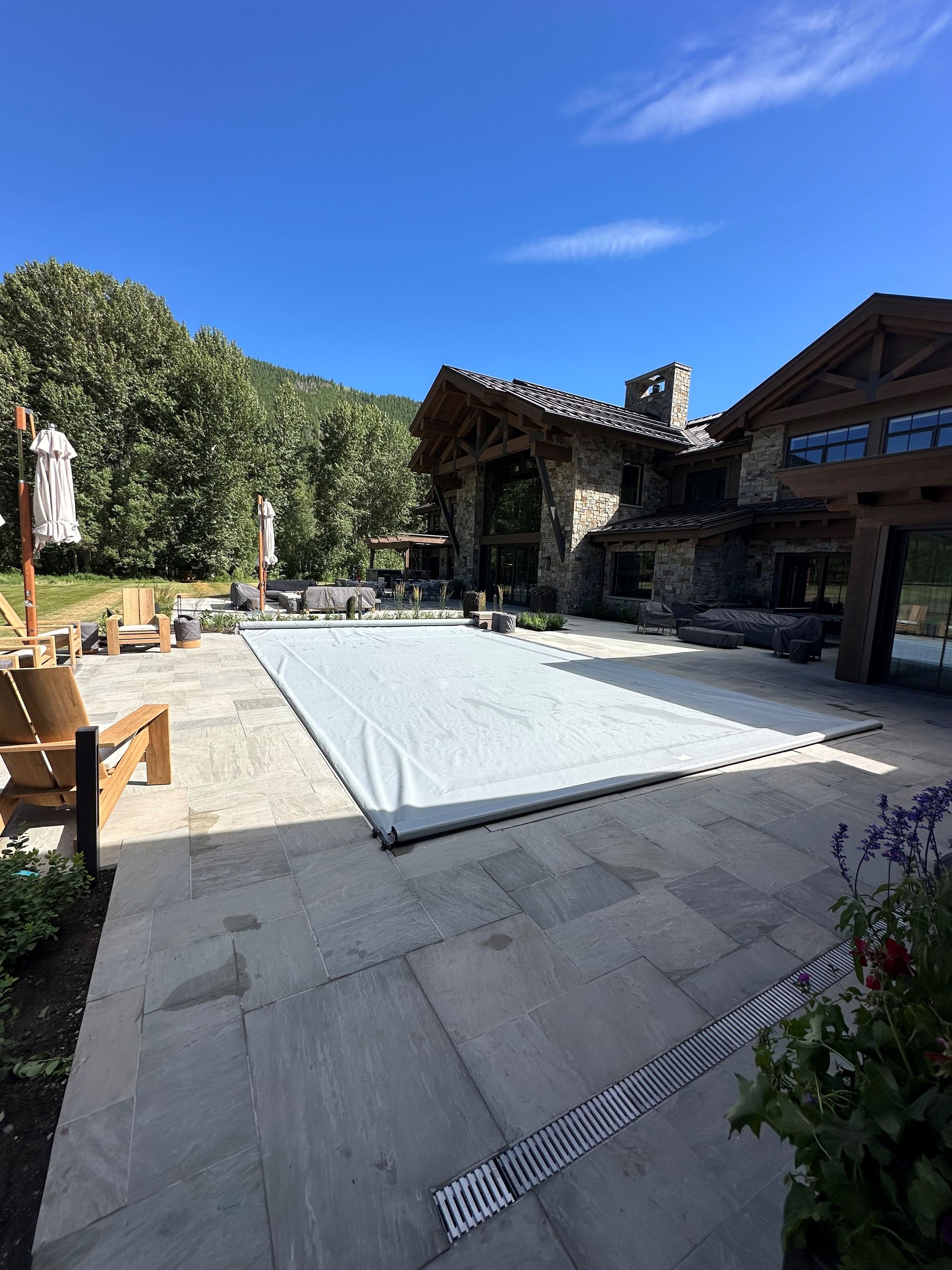 A large swimming pool is covered with a white cover.