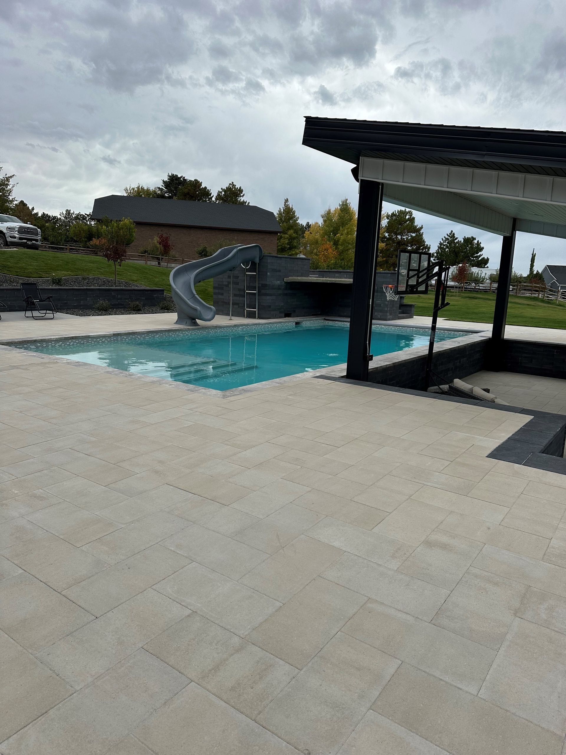 A large swimming pool with a slide in the background.