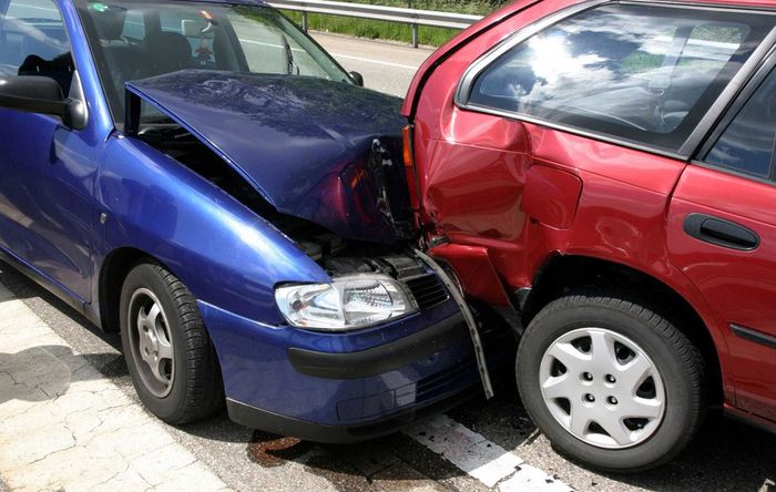 A blue car and a red car are involved in a car accident.