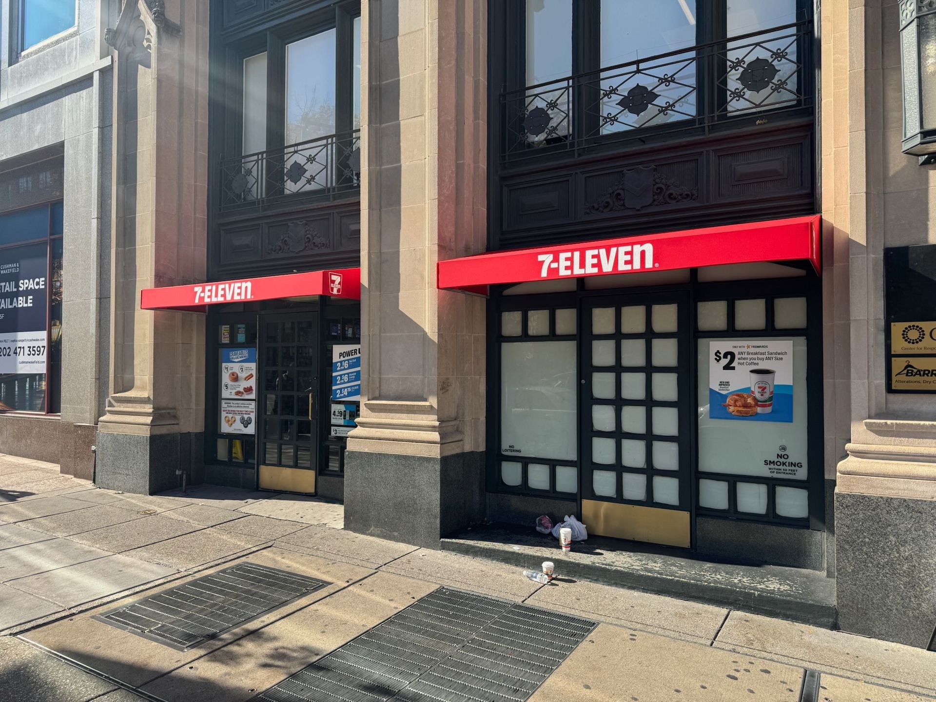 7-Eleven storefront with red awning and dark windows on a city street