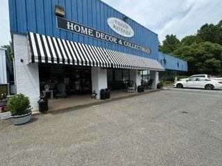 Home Decor & Collectibles storefront with black-and-white awning and parked cars outside
