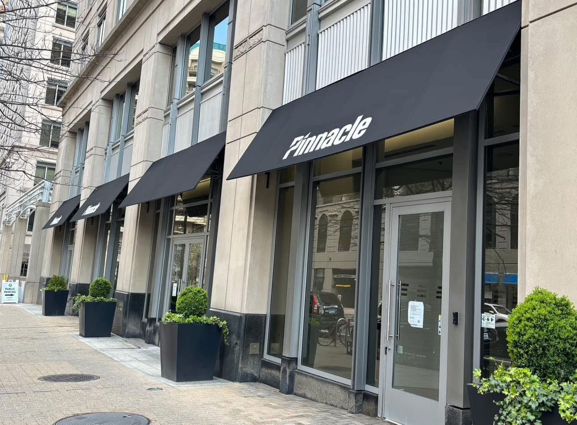 Finance bank storefront with black awnings and glass entrance on a city street