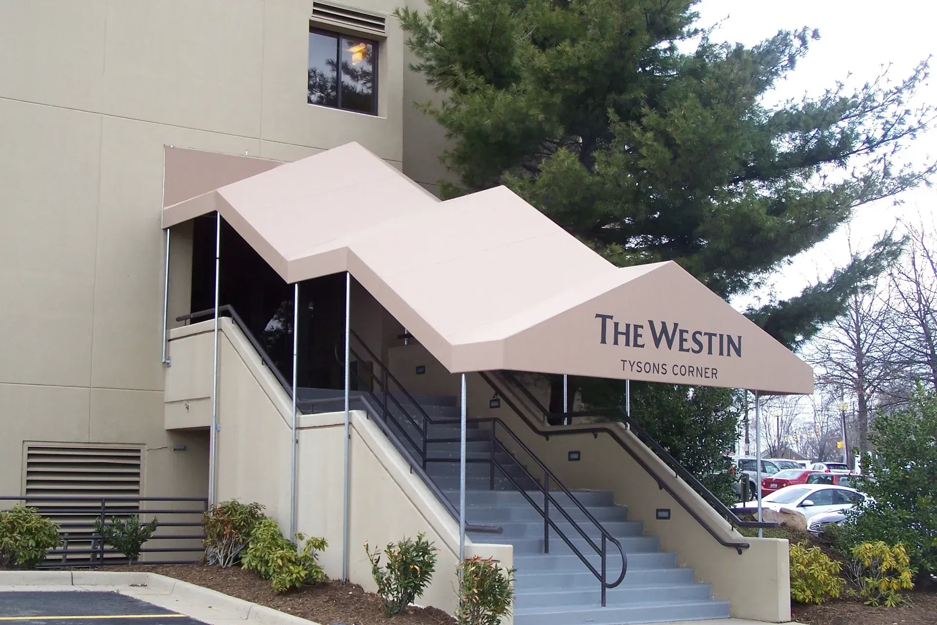 Westin hotel exterior with covered stairway entrance and steps under a white awning