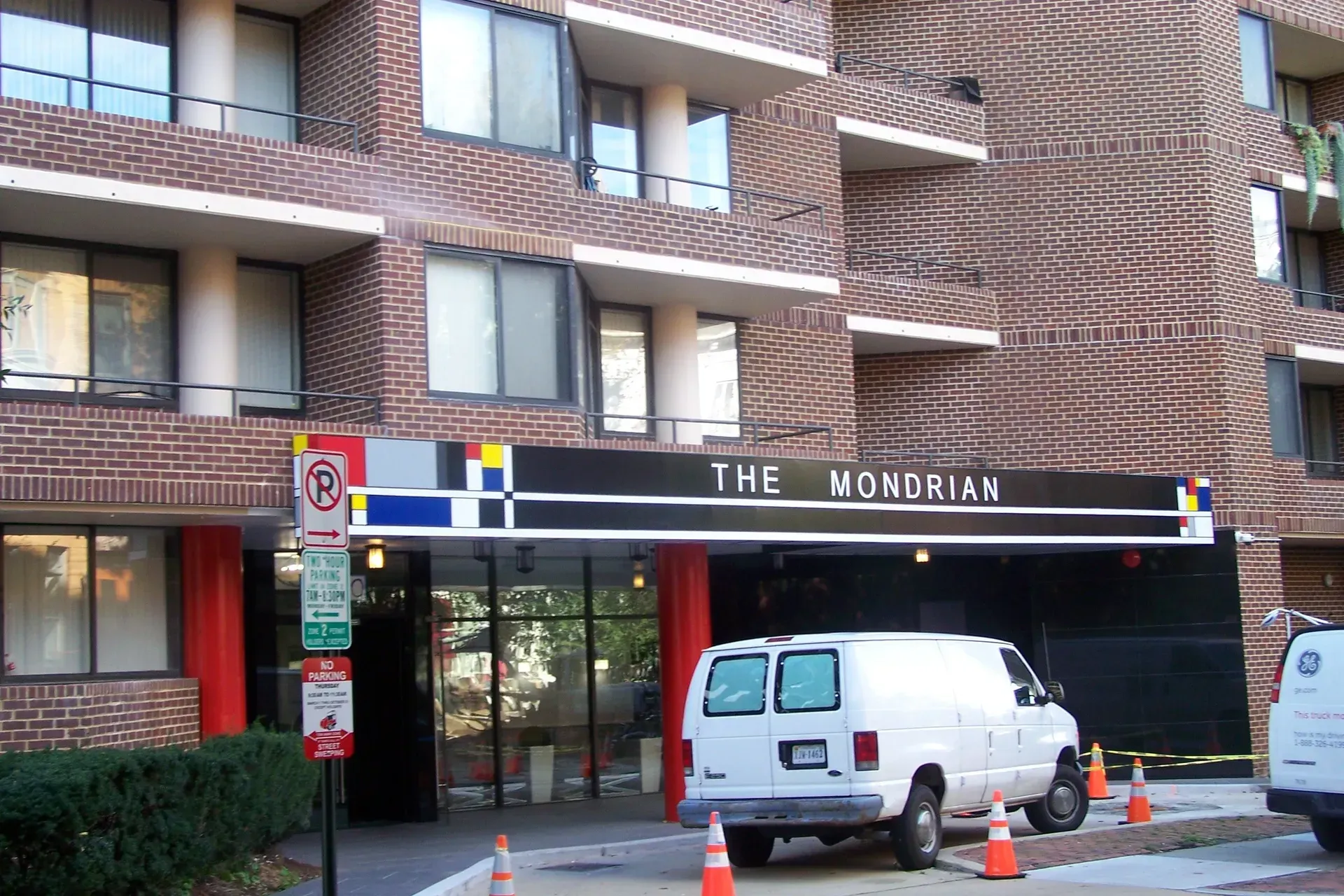 Entrance of The Monrian apartment building with a white van and orange cones in front