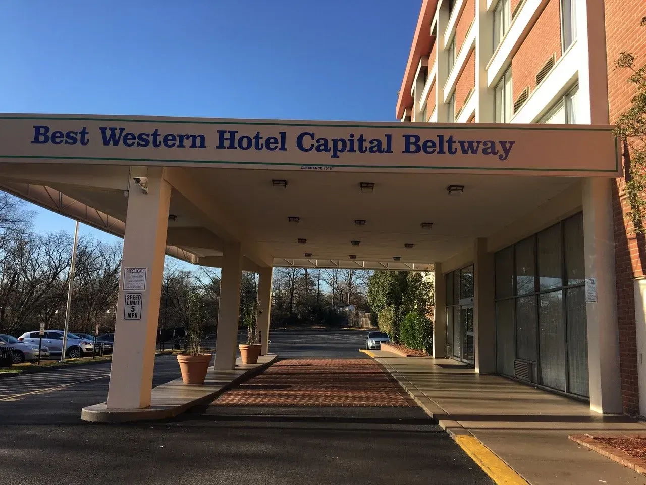 Best Western Hotel Capital Beltway entrance canopy with columns and parked cars nearby