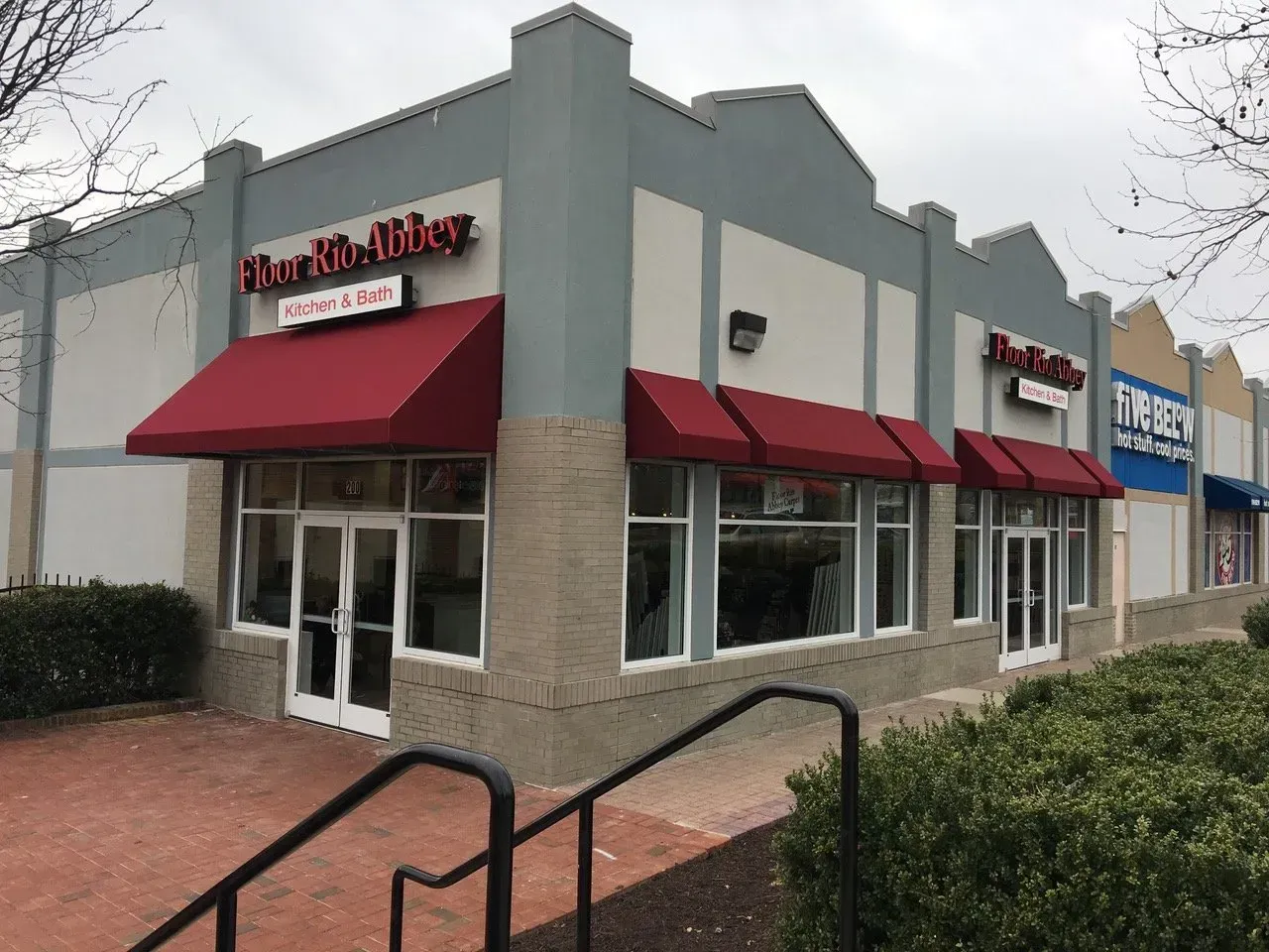 Corner Starbucks with red awnings and a white sign on a cloudy street corner.