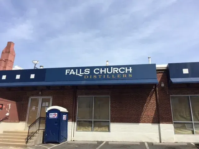 Falls Church Distillers storefront with blue awning and blue portable toilet outside