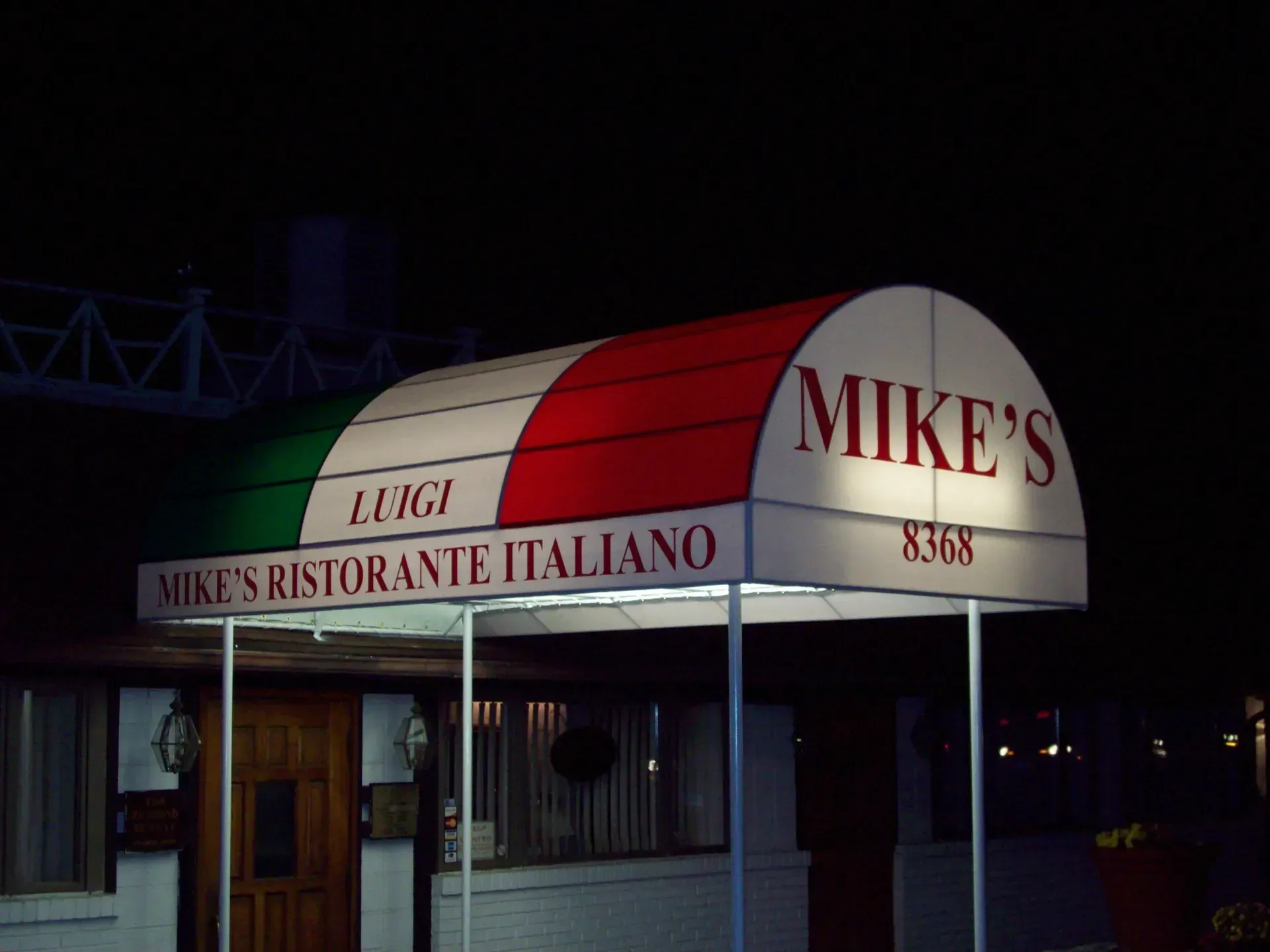 Mikes Ristorante Italiano storefront with red-and-white awning at night
