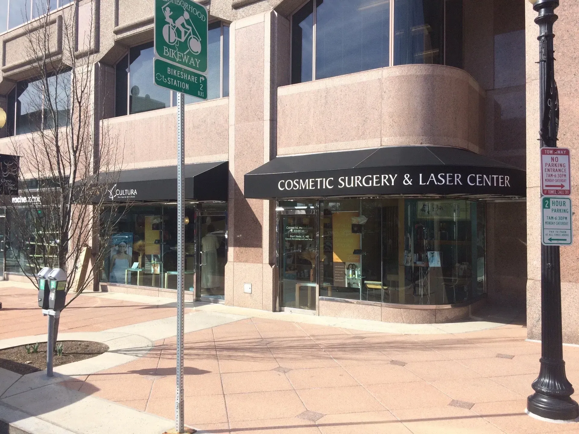 Street view of a cosmetic surgery and laser center with glass storefront and awning.