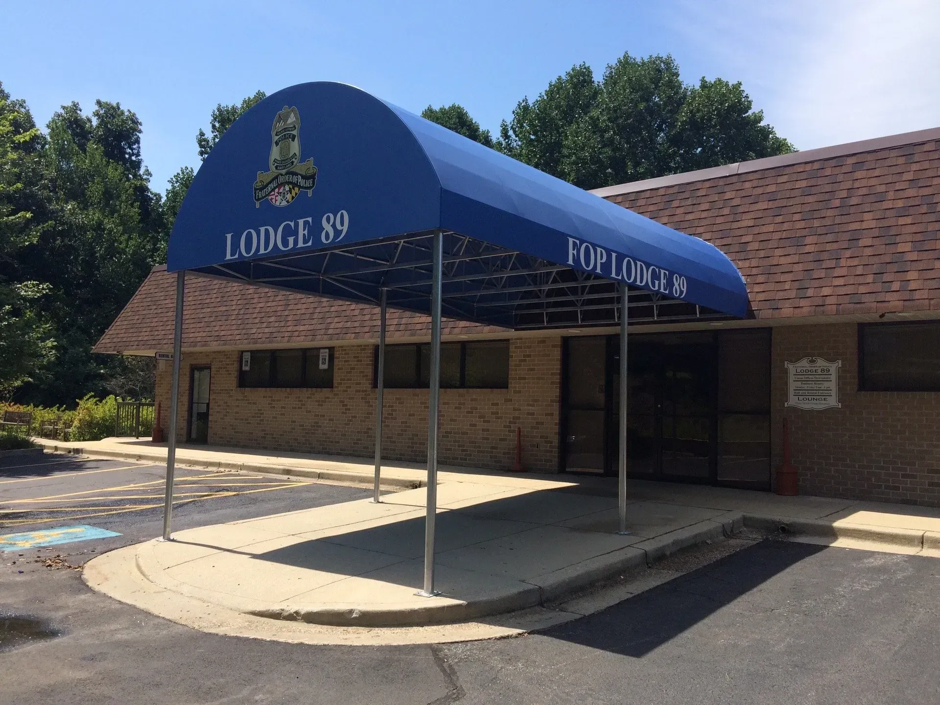 Blue awning over Lodge 89 front entrance, with brick building and covered circular driveway