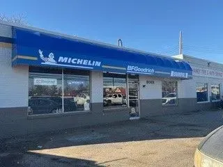 Michelin BFGoodrich tire shop storefront with blue awning and parking lot