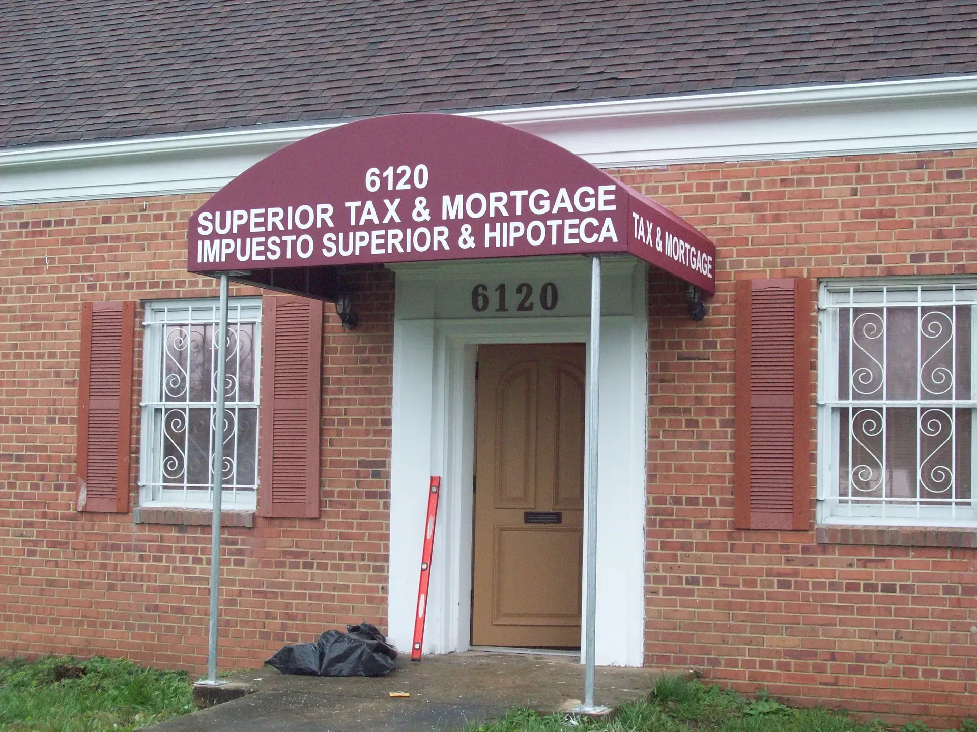 Brick office entrance with a red awning reading “Superior Tax & Mortgage,” and the number 6120 above the door