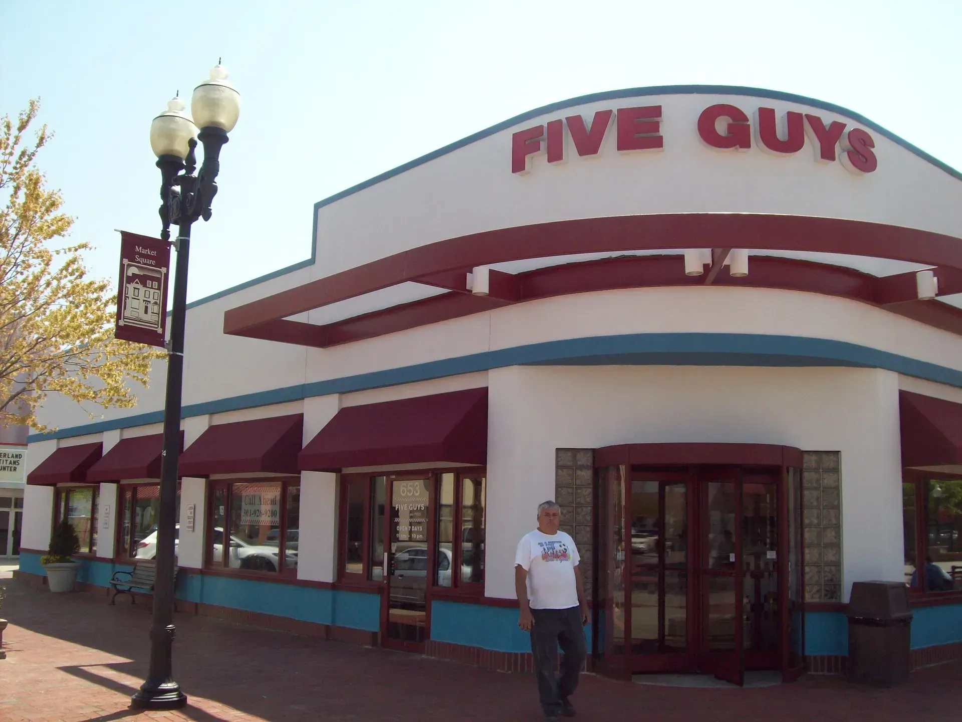Five Guys restaurant exterior with a person standing by the entrance