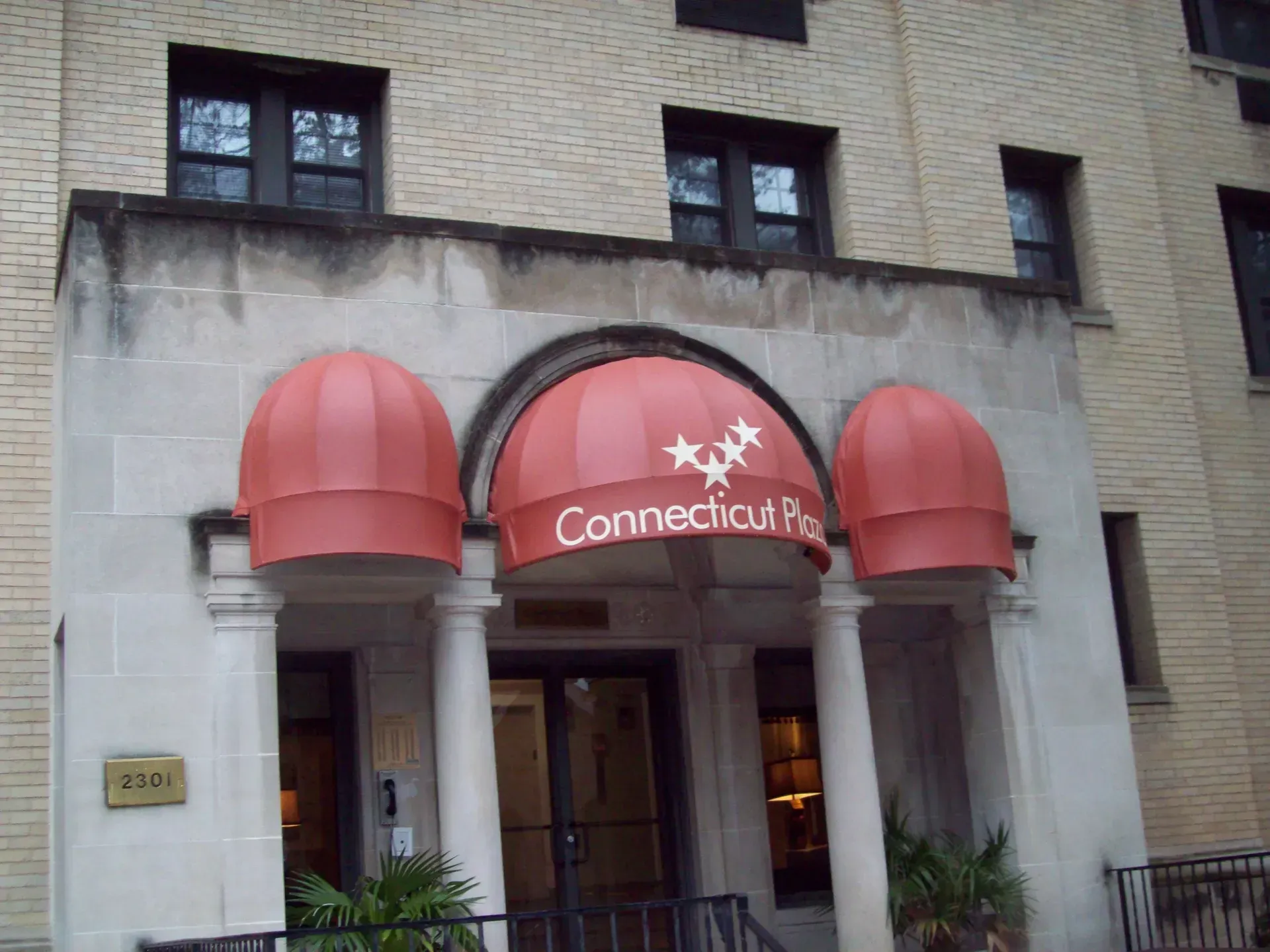 Building entrance with red awnings and a Connecticut sign above the doorway