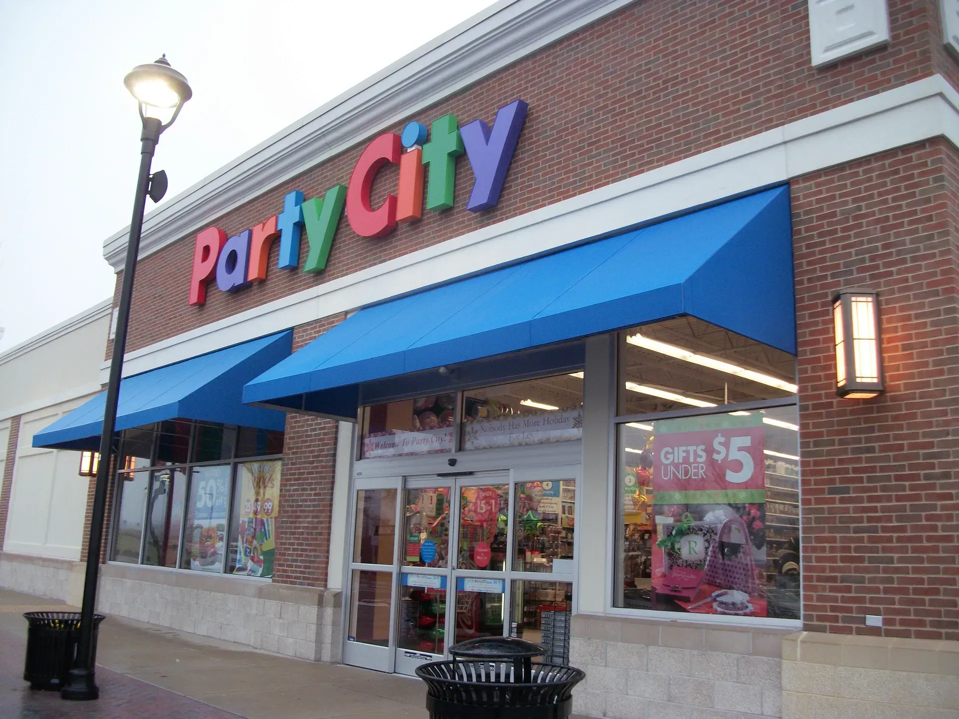 Party City storefront with blue awnings and colorful sign on a brick building