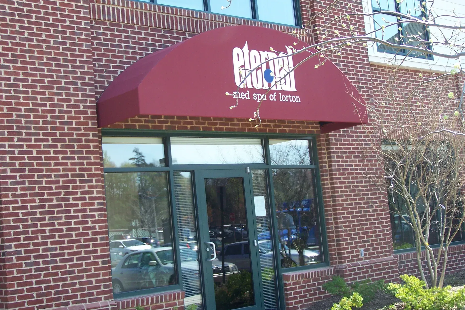 Brick building entrance with maroon awning and glass doors, marked “eclipse” above the doorway.