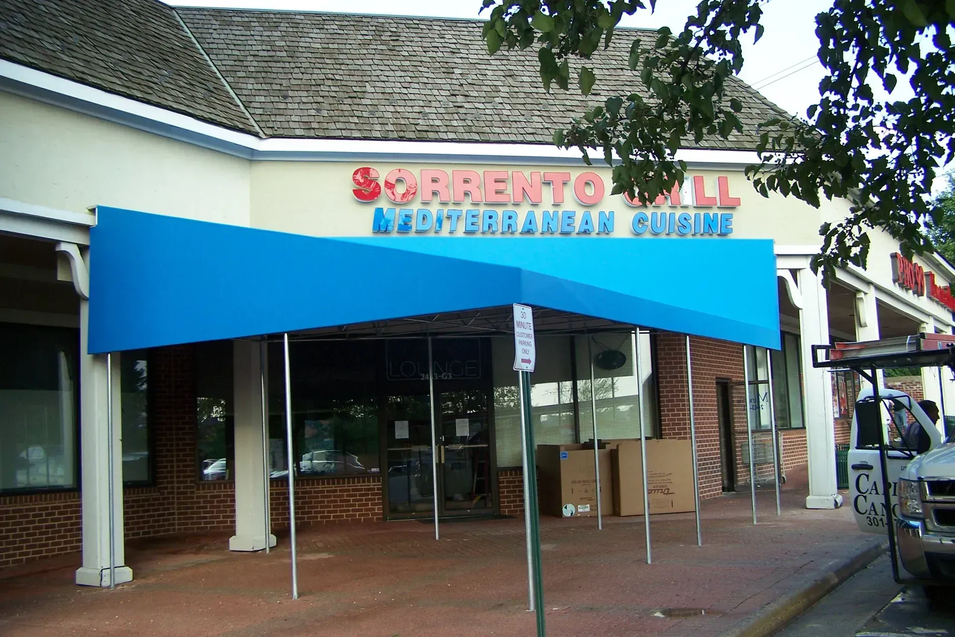 Entrance to Sacramento Mall with a blue awning and storefront signs