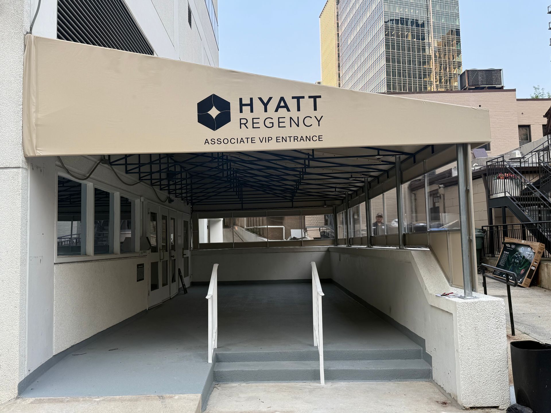 Hyatt Regency hotel entrance with covered ramp and stairs under an awning.