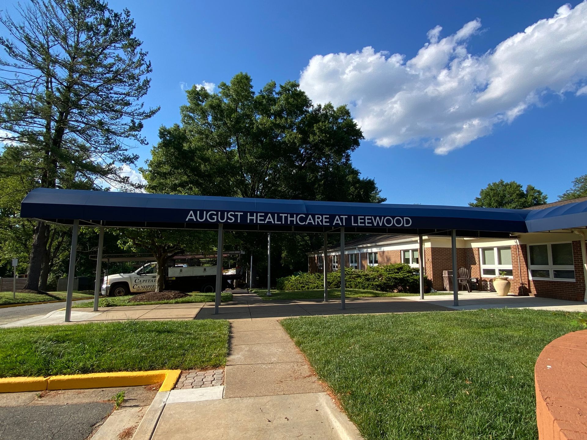 Augustine Meat Market at Cisco storefront with black awning, trees, and blue sky.