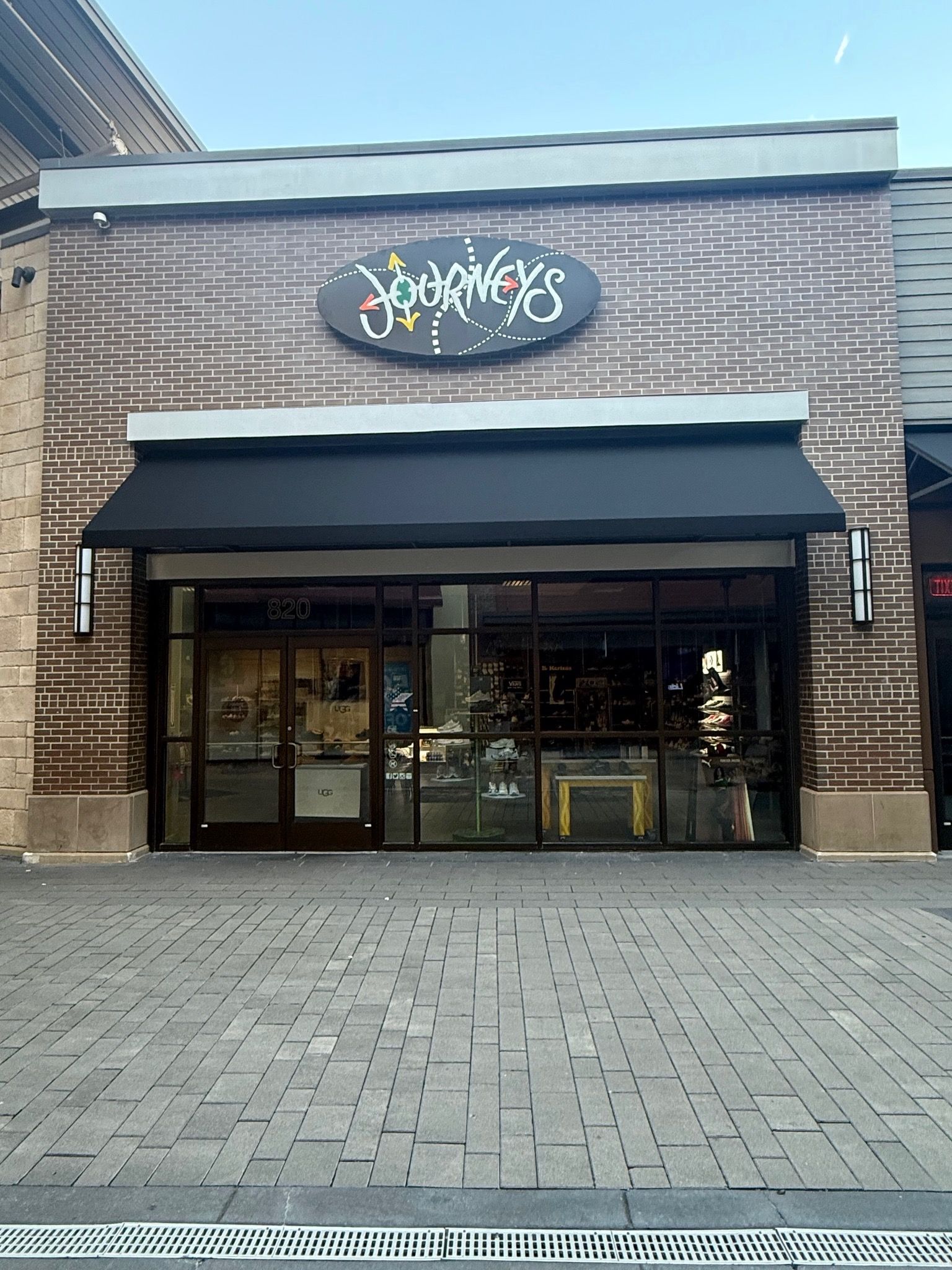 Storefront with black awning and glass doors in a brick building entrance.