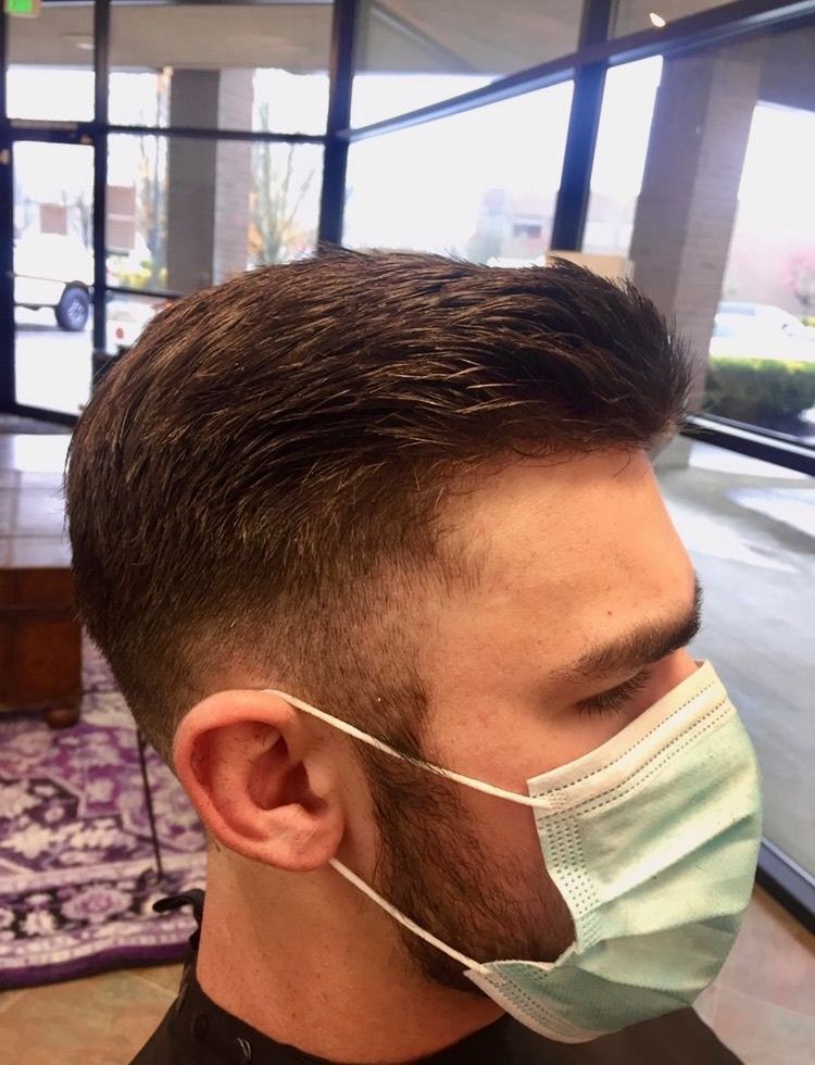 A man with a beard is wearing a face mask.