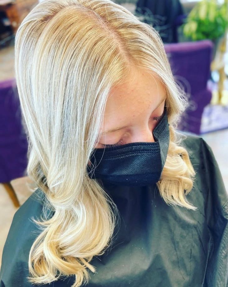 A woman with blonde hair is wearing a black mask.