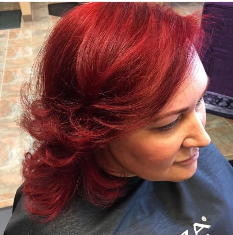 A woman with red hair is wearing a black cape