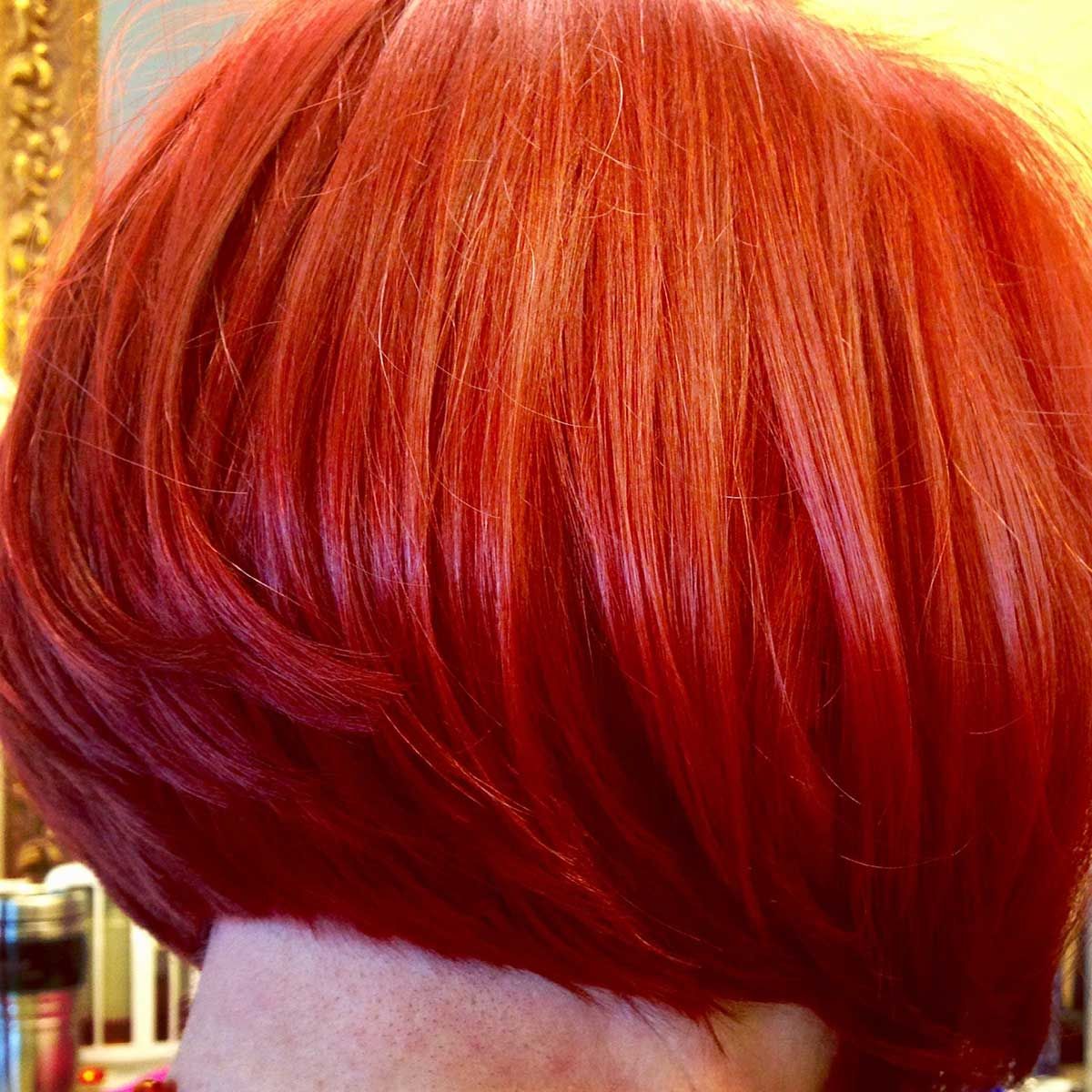A woman with red hair is wearing a bob hairstyle.