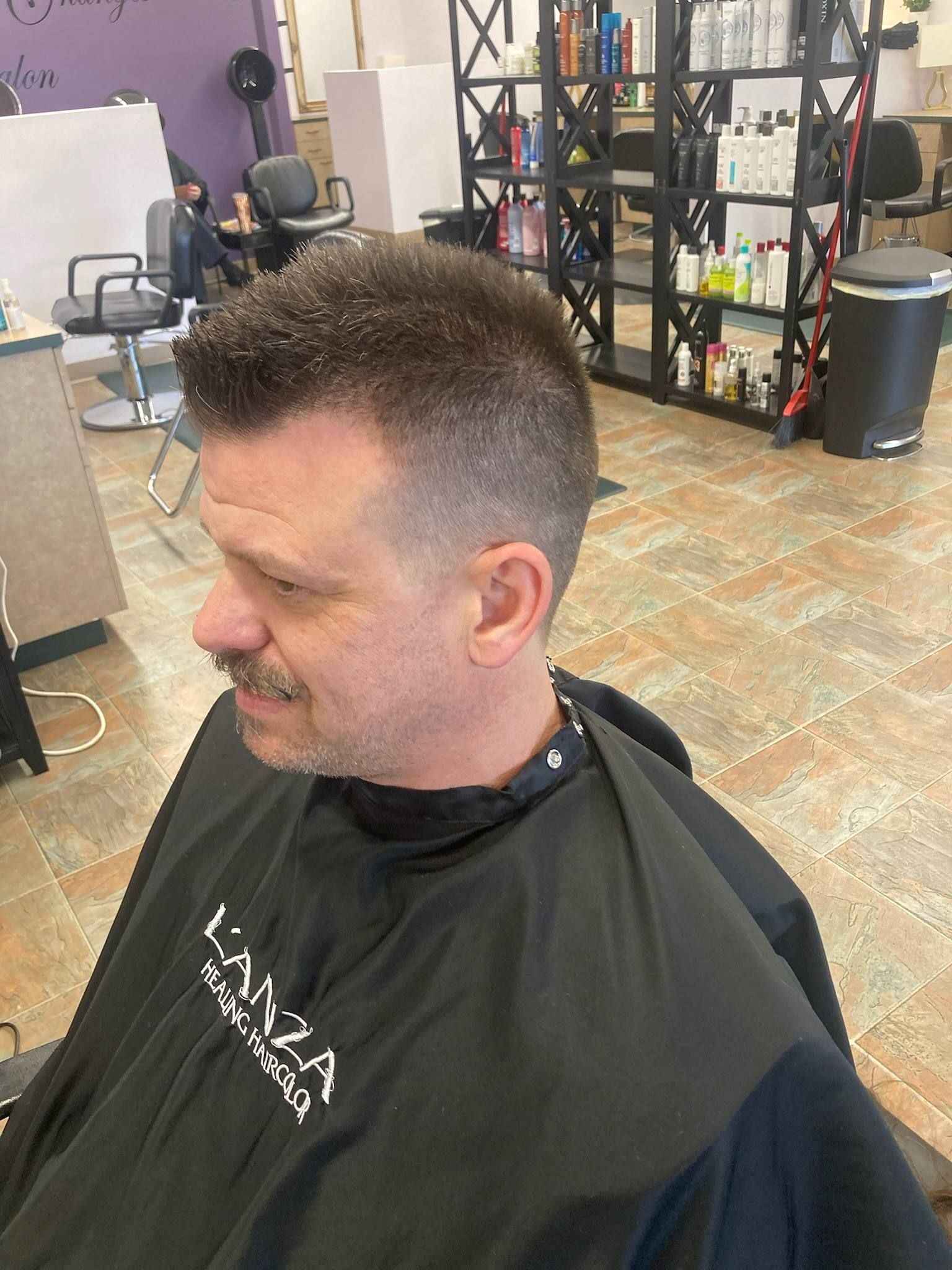 A man is getting his hair cut in a salon.